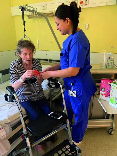 Pflegekraft Maria de Lourdes Baeza Lopez bringt die kühlende Erfrischung ans Krankenbett. | Foto: ZGH/Krankenhaus Zum Guten Hirten