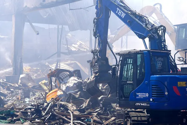 Einsatzkräfte des Technischen Hilfswerks (THW) beseitigen mit einem Bagger Schutt nach einem Feuer in einem Gewerbegebiet in Stuttgart. | Foto: Enrique Kaczor/dpa