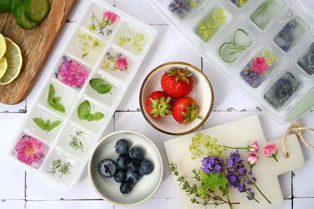 Durch schichtweises Einfrieren von Beeren, Blüten und Kräutern werden einfache Eiswürfel zu kleinen Kunstwerken. | Foto: dpa