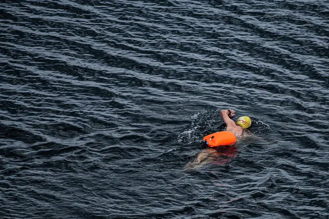 Leuchtend orange, pink oder gelb zieht sie hinter Schwimmern durchs Wasser: die Schwimmboje, befestigt über einen Gürtel. (Symbolbild) | Foto: Swen Pförtner/dpa
