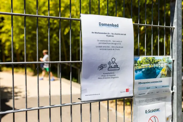 Am Tor des Lorettobads hängt die neue Einlassregel an einem Schild aus. (Archivbild) | Foto: Philipp von Ditfurth/dpa
