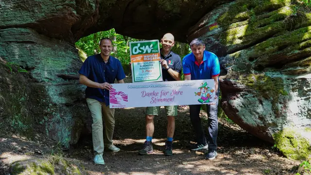 Eine Wandergruppe macht am Wegesrand Pause und blickt auf die Felsen im Pfälzerwald. | Foto: Stadt Pirmasens