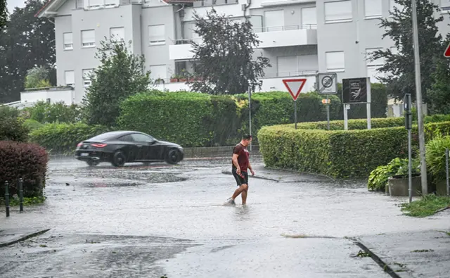 Ein Mann läuft in Friedrichshafen am Bodensee durch eine tiefe Pfütze. | Foto: Jason Tscheppljakow/dpa