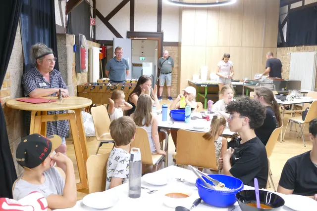 Erst ein paar Worte, dann ein Teller Spaghetti: Bürgermeister Matthias Baaß (hinten links) und Anne Gess (vorne links) beim gemeinsamen Mittagessen mit den Ferienkindern. | Foto: Stadt Viernheim