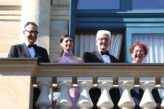 Auf dem Balkon des Festspielhauses warten Cem Özdemir, Flavia Zaka, Winfried Kretschmann und Gerlinde Kretschmann auf den Beginn des Festakts. | Foto: Karl-Josef Hildenbrand/dpa