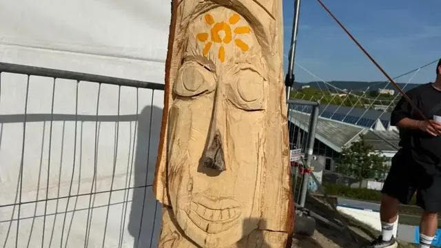Inmitten der Festivalstimmung zieht das entwurzelte Bäumchen, das bis zum heftigen Sturm auf dem Hügel stand, jetzt als Kunstwerk neugierige Blicke auf sich. | Foto: Thorsten Kornmann