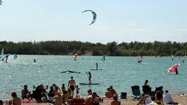Sommerstimmung am Epplesee: Besucher entspannen am Sandstrand,  Surfer und Kiter genießen den Wind auf dem beliebten Badesee bei Karlsruhe. | Foto: thk