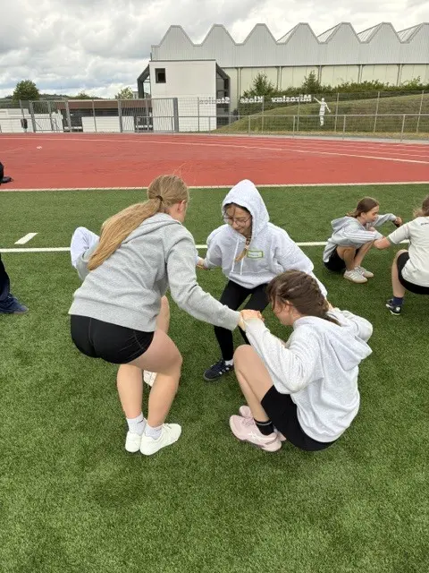 Die Jugendlichen der 7. Klasse bei einer Gruppenaufgabe auf dem Sportplatz | Foto: Michael Jung