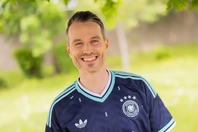 Marc Dumitru, Schauspieler der RTL-Vorabendserie «Alles was zählt» (AWZ), steht im Trikot der Deutschen Fußballnationalmannschaft auf dem Produktionsgelände. | Foto: Rolf Vennenbernd/dpa