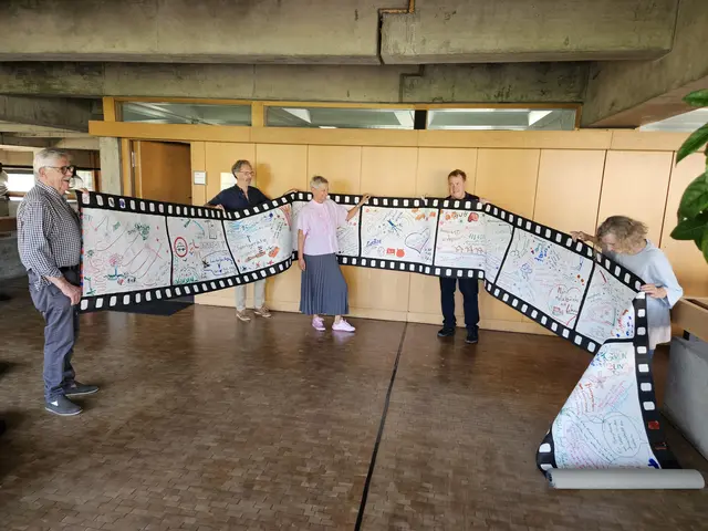 Eine über 20 Meter lange Filmrolle voller Ideen für die Zukunft Kaiserslauterns übergab die Künstlerwerkgemeinschaft an Oberbürgermeisterin Beate Kimmel. Das Foto zeigt Volker Tinti (von links), Reiner Mährlein, Oberbürgermeisterin Beate Kimmel, Michael Fetzer und Silvia Rudolf 
 | Foto: Stadt KL/gratis