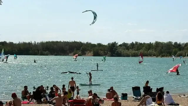 Sommerstimmung am Epplesee: Besucher entspannen am Sandstrand,  Surfer und Kiter genießen den Wind auf dem beliebten Badesee bei Karlsruhe. | Foto: thk
