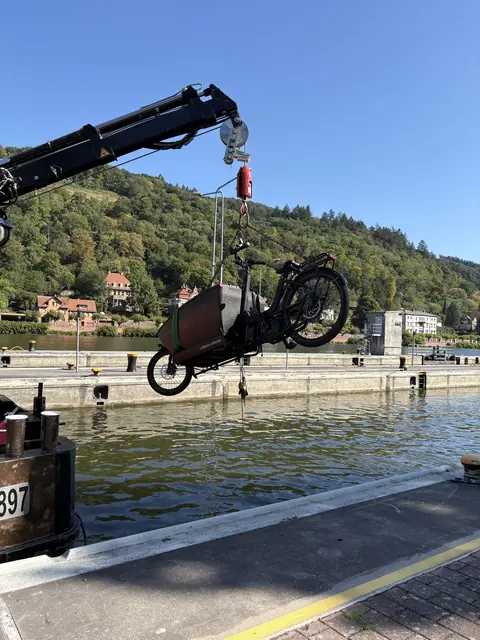 Die Bergung übernahm ein Arbeitsschiff des Wasserstraßen- und Schifffahrtsamts Neckar. Mithilfe eines Krans wurde das E-Lastenrad aus dem Wasser gezogen. | Foto: Polizeipräsidium Mannheim