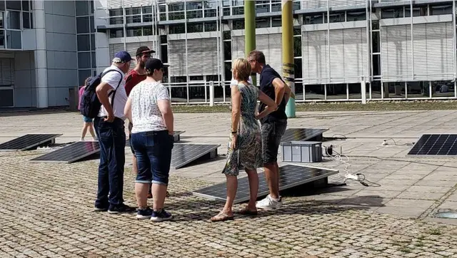 Praxisteil des Balkonsolarmodul-Mitmachworkshop: Teilnehmerinnen und Teilnehmer versammeln sich um Balkonsolarmodule, um ihre Funktion, den Einfluss von Verschattung und vieles Weitere zu verstehen. | Foto: Scientists for Future