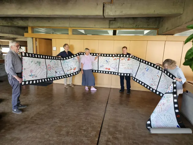 Eine über 20 Meter lange Filmrolle voller Ideen für die Zukunft Kaiserslauterns übergab die Künstlerwerkgemeinschaft an Oberbürgermeisterin Beate Kimmel. Das Foto zeigt Volker Tinti (von links), Reiner Mährlein, Oberbürgermeisterin Beate Kimmel, Michael Fetzer und Silvia Rudolf 
 | Foto: Stadt KL/gratis