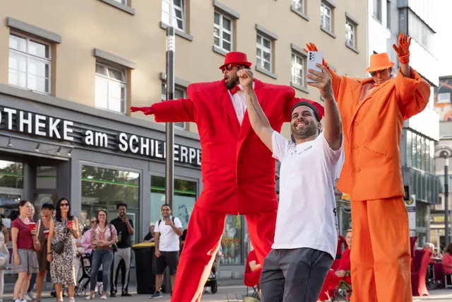 Das Stelzenpaar in Rot und Orange begeisterte die Menschen | Foto: Guerel Sahin/Peaks Agency/gratis