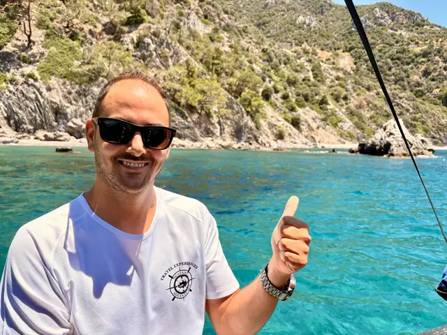 Mit erhobenem Daumen und einem Lächeln ohne jede Pose steht Ntinos Kalialis – von allen nur Dinos genannt – am Bug seines Bootes vor der schroffen Küste bei Plomari: Sohn einer Familie von Olivenbauern, deren Handwerk er bis heute fortführt, gründete er 2018 gemeinsam mit seiner Frau Aspasia das Unternehmen Seafari Adventures und führt seither selbst die Touren zu den verborgenen Buchten und warmen Quellen der Insel, deren Geschichten er unterwegs erzählt, so wie nur ein Einheimischer sie kennt.
 | Foto: Daniel J. Basler