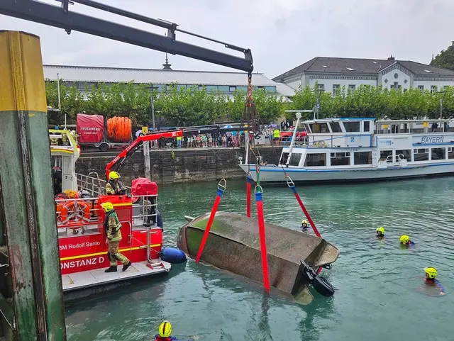 Feuerwehrleute bergen das gekenterte Motorboot.  | Foto: Handout / Berlin/Feuerwehr Konstanz/dpa