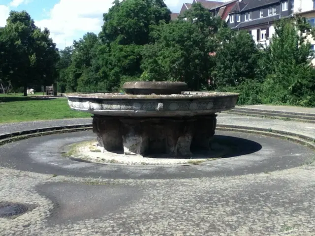 Der Brunnen kommt aus dem Jahr 39, und wird nicht mehr gepflegt, sei es, weil der Beton ohnehin zu sehr bröckelt oder weil er Erbe aus der Zeit des Nationalsozialismus ist. Er erinnert an die die Eingliederung der "Ostprovinzen ins Deutsche Reich, die Nazis nannten dies "Befreiung". Abgebildet sind auf der Motiv menschliche Köpfe, denen durch den Kalk etwas Geisterhaften anhaftet.  | Foto: JG