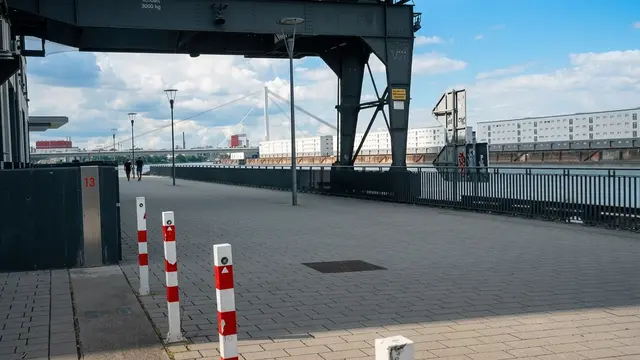 Ein Ort mit Potenzialen: Ein großer repräsentativer Platz am Rheinufer, der durch Relikte für Hafenromantik sorgt, könnte direkt am Flussufer entstehen. Die Parkplätze von Bank und Bürogebäude werden nicht komplett genutzt.  | Foto: JG