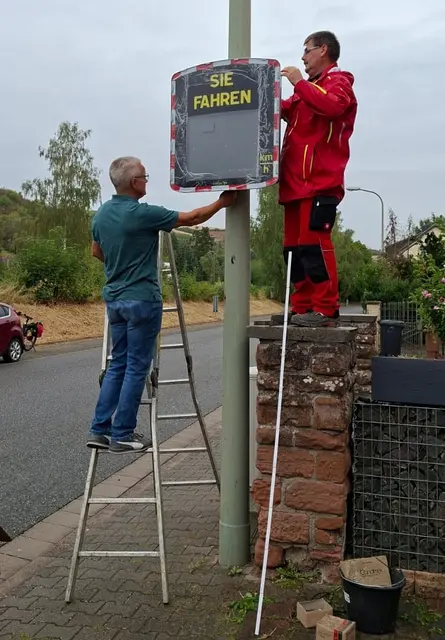Mathias Roßbach (Leiter) und Gemeindemitarbeiter Heinz-Dieter Stark bei der Installation der neuen Geschwindigkeitsmeßanlage in der Alsenzer Hauptstraße  | Foto: Arno Mohr 