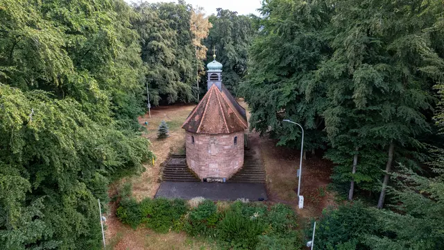 Fast vollständig vom Wald umschlossen: Von der Rückseite zeigt sich besonders gut die ungewöhnliche Form der Marienkapelle auf der Atzel. | Foto: Erik Stegner