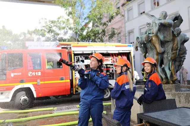 Am Alten Kaufhaus proben Jugendliche der Feuerwehr den Einsatz, während in der Innenstadt Betrieb herrscht. | Foto: Stadt Landau