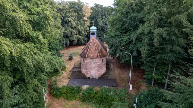 Fast vollständig vom Wald umschlossen: Von der Rückseite zeigt sich besonders gut die ungewöhnliche Form der Marienkapelle auf der Atzel. | Foto: Erik Stegner