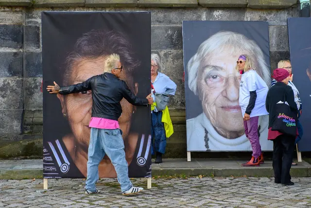 Fotograf Luigi Toscano trägt ein Porträt eines Holocaust-Überlebenden vor dem Dom. | Foto: Klaus-Dietmar Gabbert/dpa
