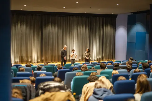 Schülerinnen und Schüler lauschen einem Filmgespräch im Kino