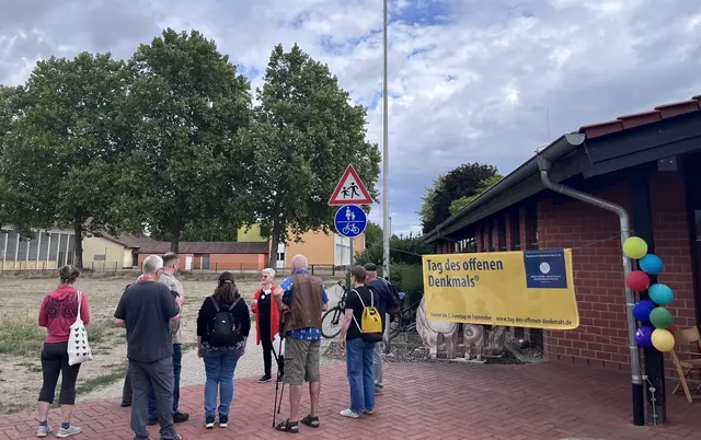 Besuchergruppe zwischen dem Schutzbau der römischen Brennöfen am Faustina-Kindergarten in Rheinzabern und der unter der Wiese ruhenden Römerstrasse | Foto: Barbara Thomas