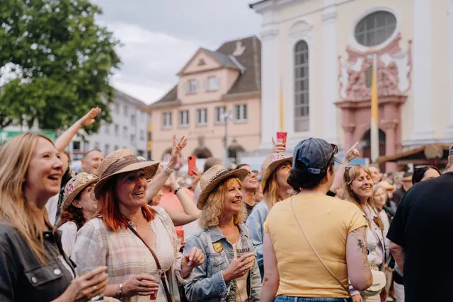 Viele Menschen kommen auf dem Rathausplatz zusammen und machen bei der Stadtwette als Spontan-Chor mit. | Foto: Sebastian Weindel, © Sebastian Weindel
