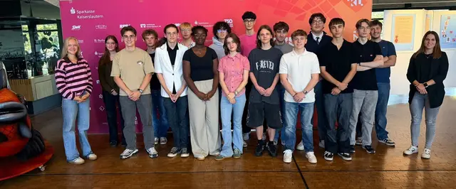 Zu sehen sind 18 Personen auf einem Gruppenbild, die in die Kamera schauen. Dabei handelt es sich um Mitglieder und Gäste der Sitzung.