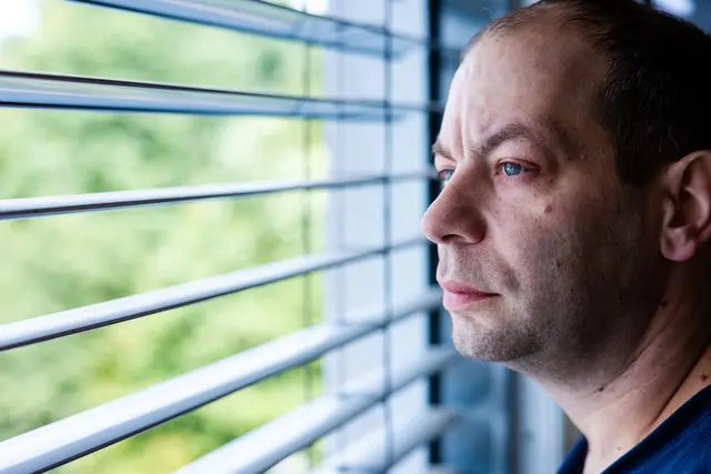 Patrik Oberleuck steht in seinem Krankenhauszimmer und schaut aus dem Fenster. Oberleuck leidet an Speiseröhrenkrebs. | Foto: Laszlo Pinter/dpa