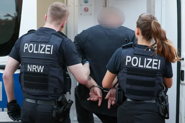 Ein Mann aus dem Umfeld der «Hells Angels» wird in Duisburg abgeführt. | Foto: Christoph Reichwein/dpa