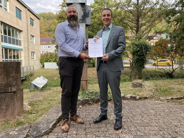 Bürgermeister Christian Burkhart überreicht Björn Meyer (links) die Ernennungsurkunde zum Verbandsgemeindeverwaltungsrat. | Foto: Verbandsgemeinde Annweiler