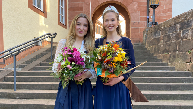 Die Krone ist übergeben: Vanessa II. (rechts) ist die neue Kastanienprinzessin des Trifelslands. Ihre Vorgängerin Felicia I. begleitete die Amtsübergabe beim Keschdefeschd in Annweiler. | Foto: Verein Südliche Weinstraße Annweiler am Trifels e.V. / KI-gestützter Beschnitt auf 16:9: Erik Stegner
