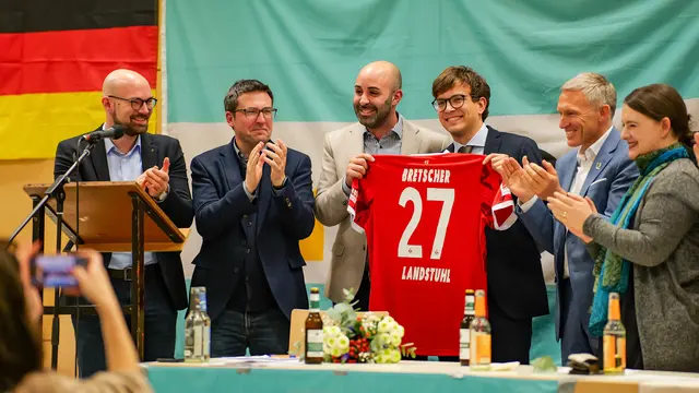 Christopher Bretscher (CDU), Gewinner der Bürgermeisterwahl in der Verbandsgemeinde Landstuhl, bei einer CDU-Veranstaltung mit einem FCK-Trikot mit der Aufschrift „Bretscher 27 Landstuhl“.