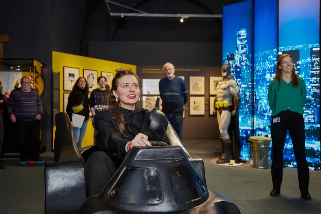 Diese Besucherin der Superheroes-Ausstellung in Speyer nimmt im Batmobil an einer rasanten Verfolgungsjagd durch Gotham City teil.  | Foto: Historisches Museum der Pfalz/Hans-Georg Merkel 