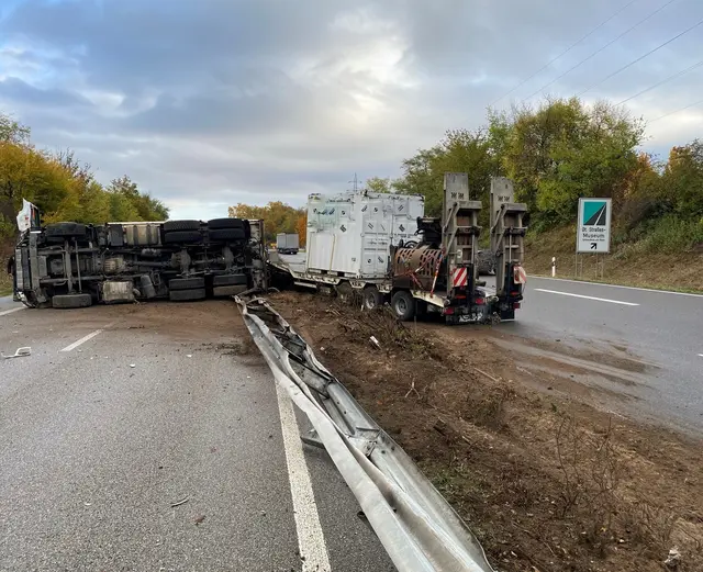 Ein Lkw durchbrach auf der B9 bei Germersheim die Mittelleitplanke und kippte auf der Gegenfahrbahn um. Bei dem Unfall wurde niemand verletzt, während der Bergung kommt es zu Sperrungen. | Foto: Polizei Germersheim