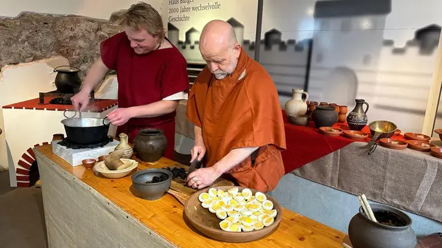 Während auf dem Herd das Essen köchelt, wissen die Akteure Spannendes über die Essgewohnheiten der Antike zu berichten – und haben auch die eine oder andere Anekdote parat. | Foto: Berg; I. Roemercohorte Opladen