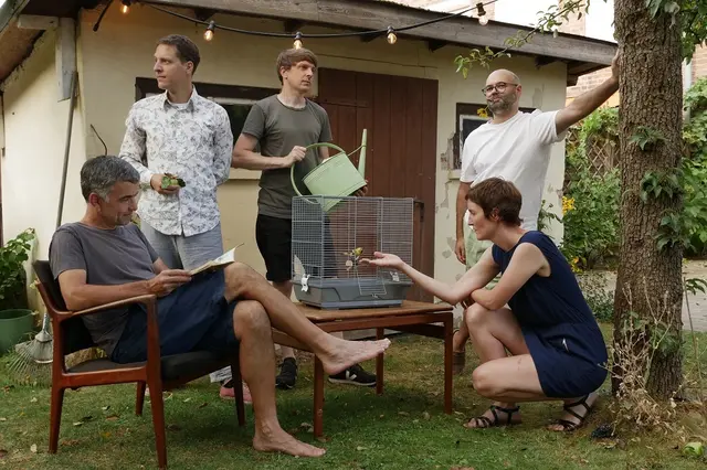Die Bandmitglieder in einem Garten. Auf dem Tisch steht ein Vogelkäfig | Foto: Thorben Surke