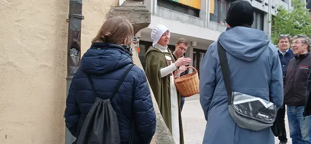 Stadtführung in der Himmelgasse in Speyer, April 2026.
Hier stand das Haus „Zum Himmel“ im Jahr 1438.
Die Stadtführerin im mittelalterlichen Gewand lässt vergangene Zeiten lebendig werden und nimmt die Besucher mit auf eine Reise in die Geschichte.  | Foto: Liubov Arnold