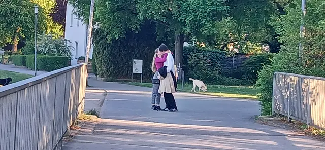Ein spontaner Moment am Rhein: Zwei Menschen bleiben auf ihrem Weg stehen und vergessen für einen Augenblick die Welt um sich herum. Zwischen Alltag und Bewegung entsteht ein kurzer Augenblick der Nähe — leise, ehrlich und ganz menschlich.  | Foto: Liubov Arnold