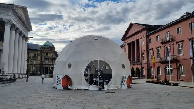 Beim ZKM-Projekt „Mars!platz: Red Dust City“ simulieren drei Künstler in einer Kuppel auf dem Karlsruher Marktplatz das Leben auf dem Mars. Zwei Wochen lang testen sie unter angepassten Bedingungen Themen rund um Ressourcenknappheit, Isolation, "Mental Health" und Zusammenleben. Die Erkenntnisse sollen als Blaupause für das Überleben auf einer klimagestressten Erde dienen. | Foto: www.jowapress.de